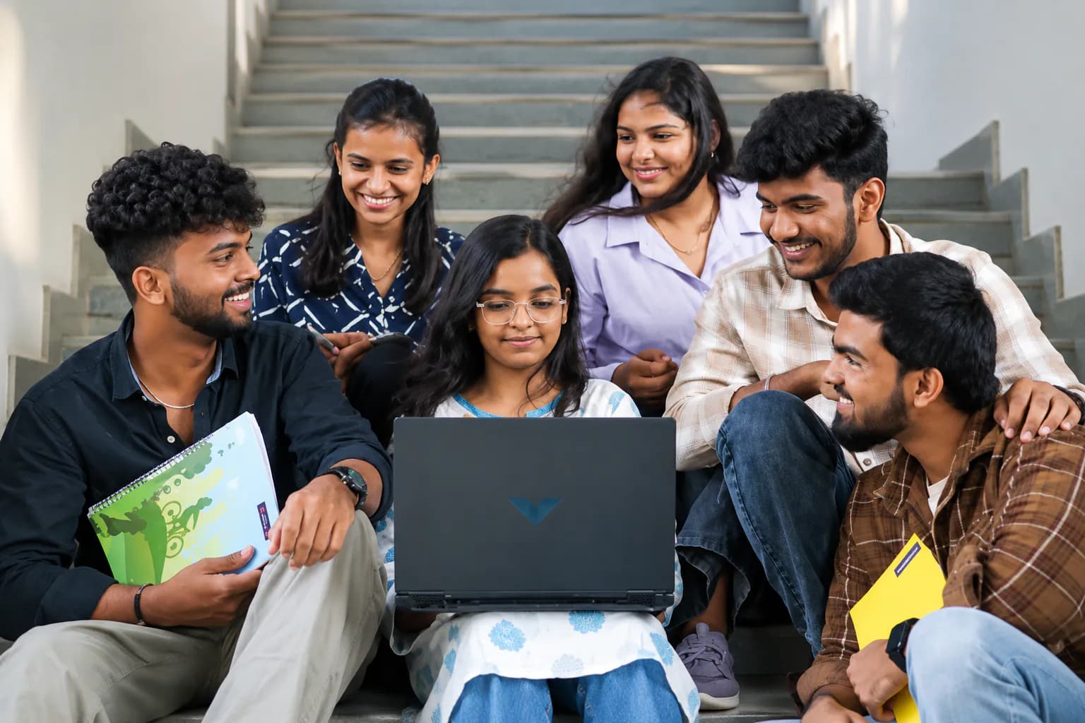A group of students studying together on campus steps